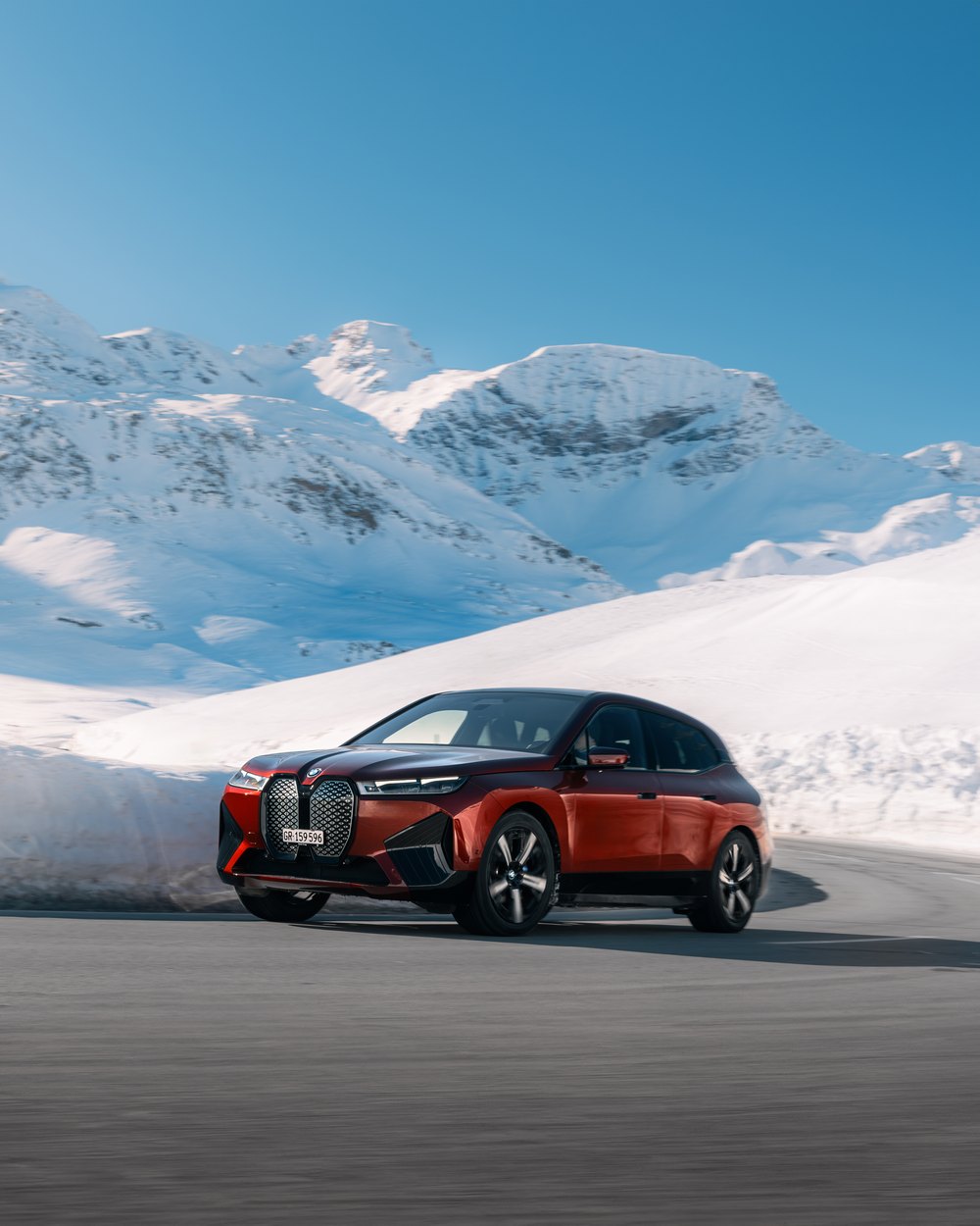 BMW iX on a snow lined mountain pass in Switzerland