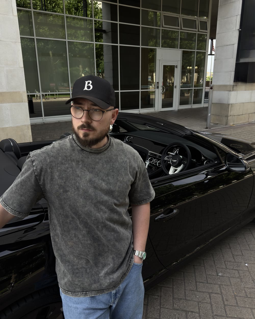 George Colbeanu standing beside a black Bentley convertible