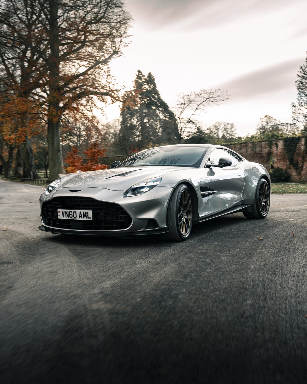 Aston Martin Vanquish on a country road lined with autumn trees